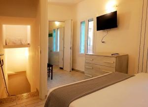a bedroom with a bed and a dresser with a television at Il Rifugio delle Valli in Comacchio