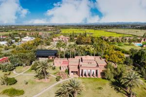an aerial view of a pink building with palm trees at Dar Kamango - Marrakech Peaceful Retreat in Marrakesh