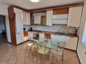 a kitchen with a glass table and white cabinets at Ali Gio in Alzano Lombardo