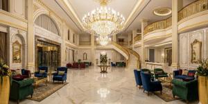 a large lobby with a chandelier and blue chairs at Zefir Apart in Ordu