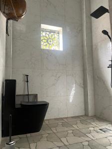 a bathroom with a black toilet and a window at Villa Sara DIALLO in Ngaparou +14 photos