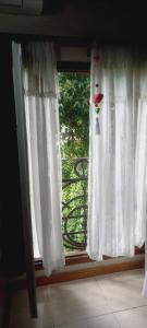 a window with a white curtain with a bird on it at Habitaciones Cecy in General Juan Madariaga