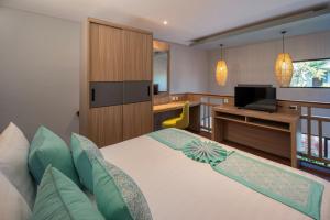 a hotel room with a bed and a television at The New Moon Umalas in Seminyak +26 photos