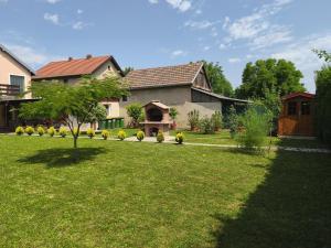 a house with a yard with a tree in it at Apartmani Astra in Vukovar