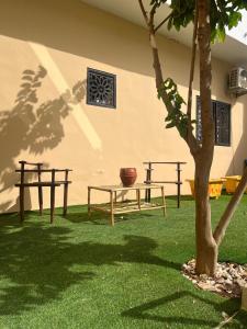 a patio with a table and a tree in a yard at Villa Sara DIALLO in Ngaparou
