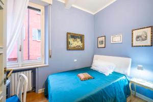 a blue bedroom with a bed and a window at Appartamento San Giovanni - centro storico di Parma in Parma
