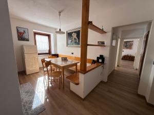 a kitchen and dining room with a table and chairs at Appartamento Moena in Moena