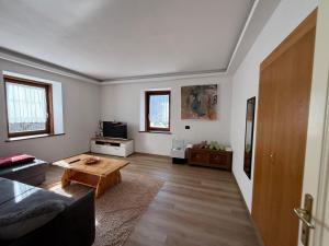 a living room with a couch and a table at Appartamento Moena in Moena