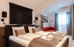 a bedroom with two beds and a red chair at Villa Dragana with heading swimming pool and parking in Budva +57 photos