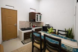 a kitchen with a table and chairs in a room at Alayam Villa Padalarang near whoosh, wahoo waterworld & ikea in Padalarang