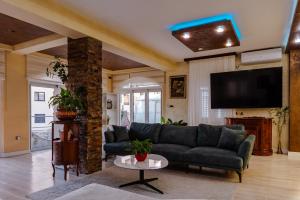 a living room with a couch and a tv at Villa Dragana with heading swimming pool and parking in Budva