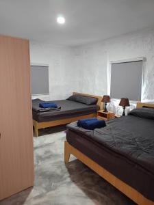 a bedroom with two beds and two windows at Art rock garden in Ko Lipe
