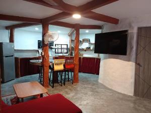 a living room with a television and a table with chairs at Art rock garden in Ko Lipe