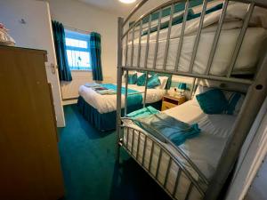 ein Zimmer mit zwei Etagenbetten und einem Fenster in der Unterkunft Beeches Hotel in Blackpool
