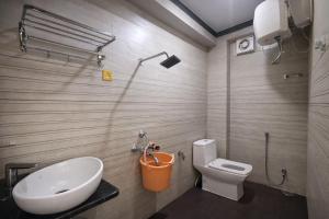 a bathroom with a white toilet and a sink at The Nest Kashi in Varanasi