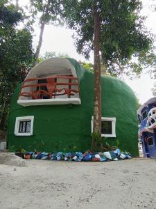 a green dome house with a window and a tree at Art rock garden in Ko Lipe