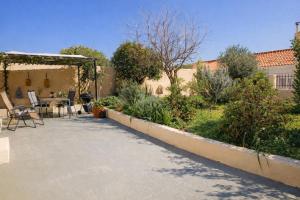 a patio with a table and chairs in a garden at Nafplio Cottage-Grandma's Yard in Asíni