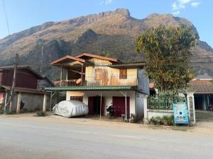 a building on the side of a street with a mountain at KP Backpackers Hostel in Nongkhiaw