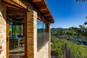 a brick house with a balcony with a view of the mountains at Casa Priora vista Sibillini in Montefortino +5 photos