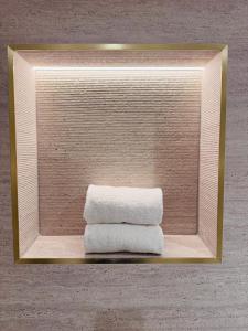 a mirror with a stack of towels on a shelf at Connemara Sands Hotel & Spa in Clifden +180 photos