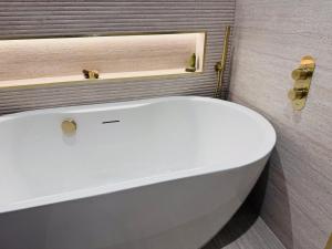 a white bath tub in a bathroom with a window at Connemara Sands Hotel & Spa in Clifden