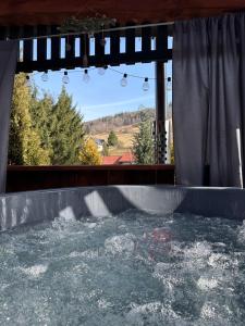 a hot tub on a patio with water at Domek Pluto Konradów 1 in Lądek-Zdrój