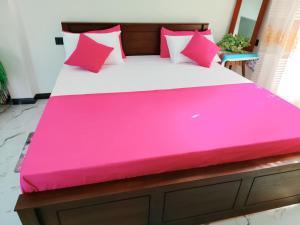a large bed with a pink cover on it at OCEAN Wild Trail in Hikkaduwa +22 photos