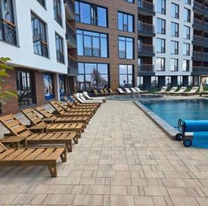 a pool with lounge chairs next to a building at Misho Hills Retreat in Kopaonik