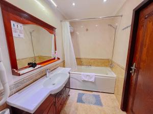 a bathroom with a tub and a sink and a bath tub at Taj Palace Hotel & Spa in Dushanbe +27 photos