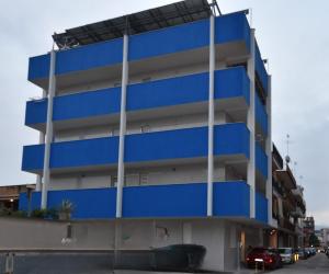 a blue building with cars parked in front of it at House Nonno Viky in Volla