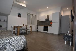 a bedroom with a bed and a kitchen with a table at House Nonno Viky in Volla