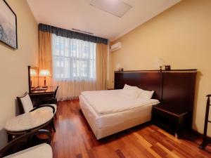 a hotel room with a bed and a window at Taj Palace Hotel & Spa in Dushanbe
