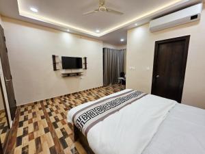 a bedroom with a bed and a flat screen tv at Crestview Inn in Lucknow