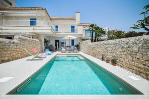 a swimming pool in front of a house at Villa Almaris in Marina di Ragusa