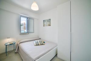 a small white bedroom with a bed and a window at Villa Almaris in Marina di Ragusa +32 photos