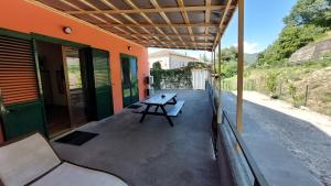 a patio with a table and benches on a house at Rosa Room in Castelnuovo Cilento
