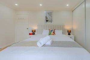 a bedroom with a large white bed with two towels at Villa Oberon in Oberon