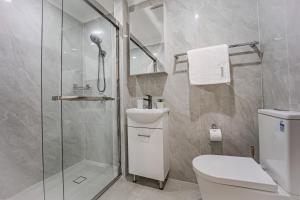 a bathroom with a shower and a toilet and a sink at Villa Oberon in Oberon +15 photos