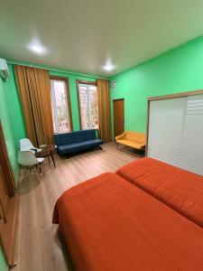 a bedroom with a bed and a couch and a table at Green Home in Kobuleti