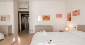a bedroom with a large white bed with towels on it at Dimoras 3BR City Center Terrace & Parking in Olbia +3 photos