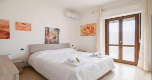 a bedroom with a white bed with towels on it at Dimoras 3BR City Center Terrace & Parking in Olbia
