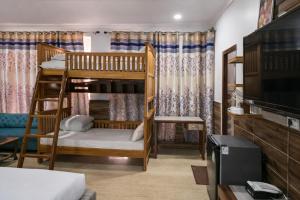 a room with two bunk beds and a flat screen tv at The Asanar Hills in Rūpnagar +72 photos