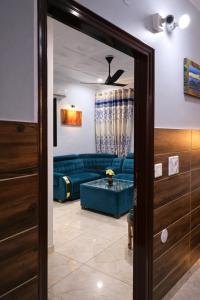 a living room with a blue couch and a glass door at The Asanar Hills in Rūpnagar