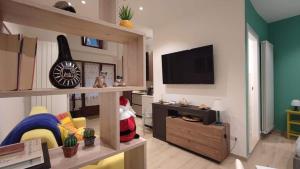a living room with a flat screen tv and a guitar at Il Loft di Pieve in Città della Pieve