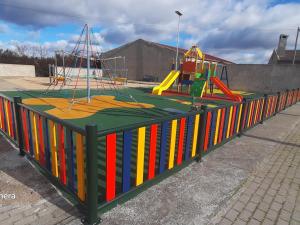a play area with a playground with colorful fences at Mallona in Pedro Rodríguez