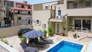 a house with a swimming pool and an umbrella at Villa Damiani " Partys and loud music forbidden!!!" in Pula