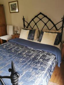 a bedroom with a bed with a blue comforter at Le Petit Verger in Grumesnil