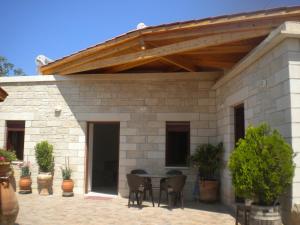 a patio with a wooden roof and a table and chairs at Marias Alikambos in Alikampos