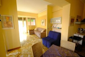 a living room with a blue chair and a couch at Palma Residence Rapallo by PortofinoVacanze in Rapallo