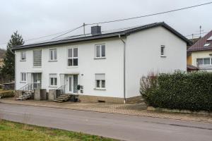a white house on the side of a street at Talblick - Apartment Hortensie in Losheim